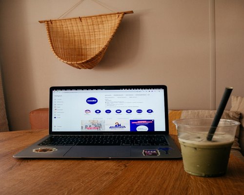 Calm neighborhood coffee shop setting with laptop and cup